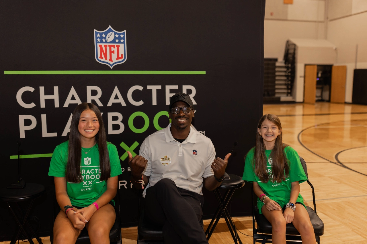 Presenter smiling with students at Character Playbook Event