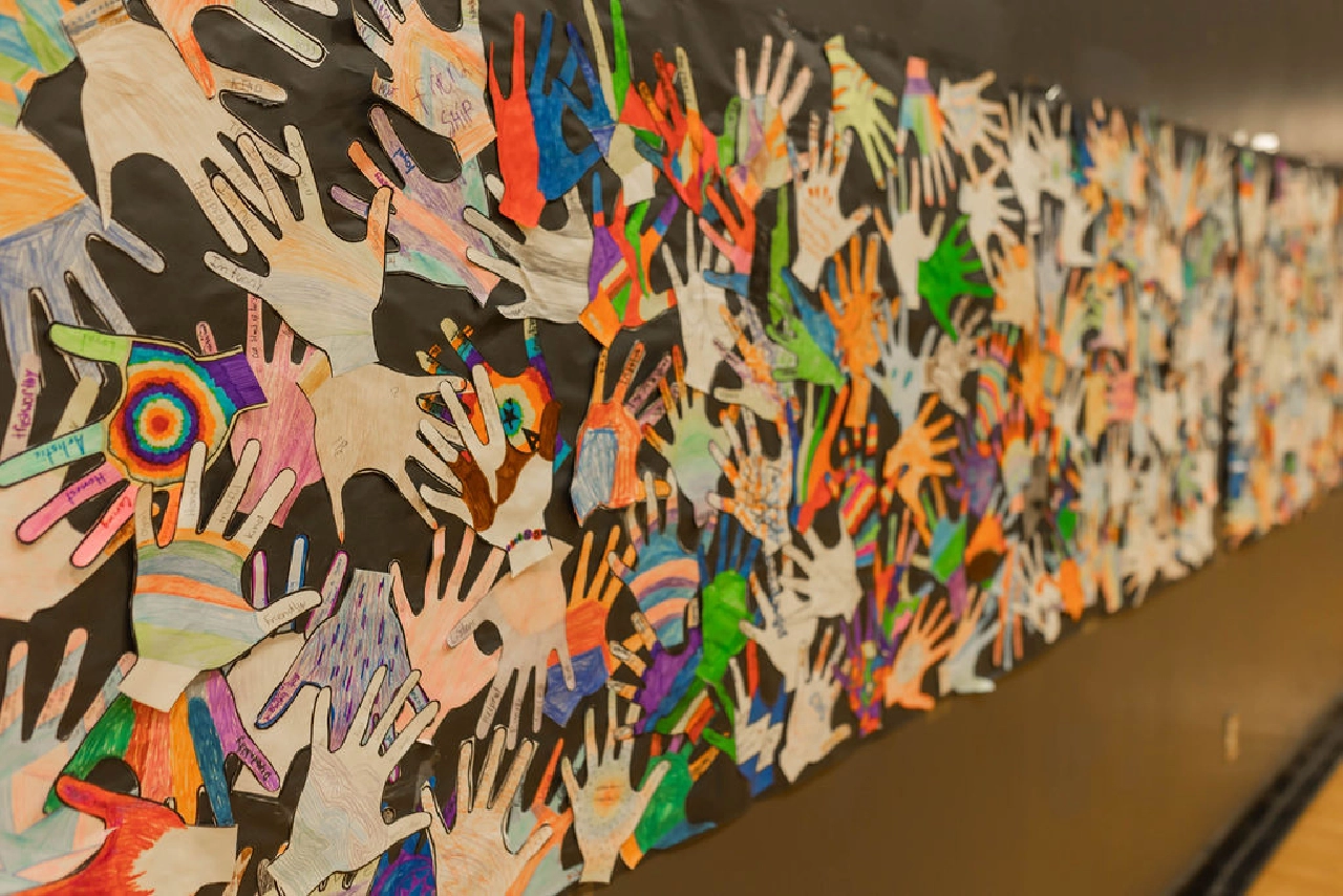 Collage of hand art on school wall