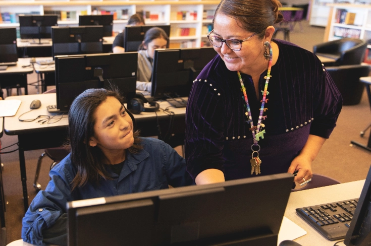 Teacher working with student in computer lab